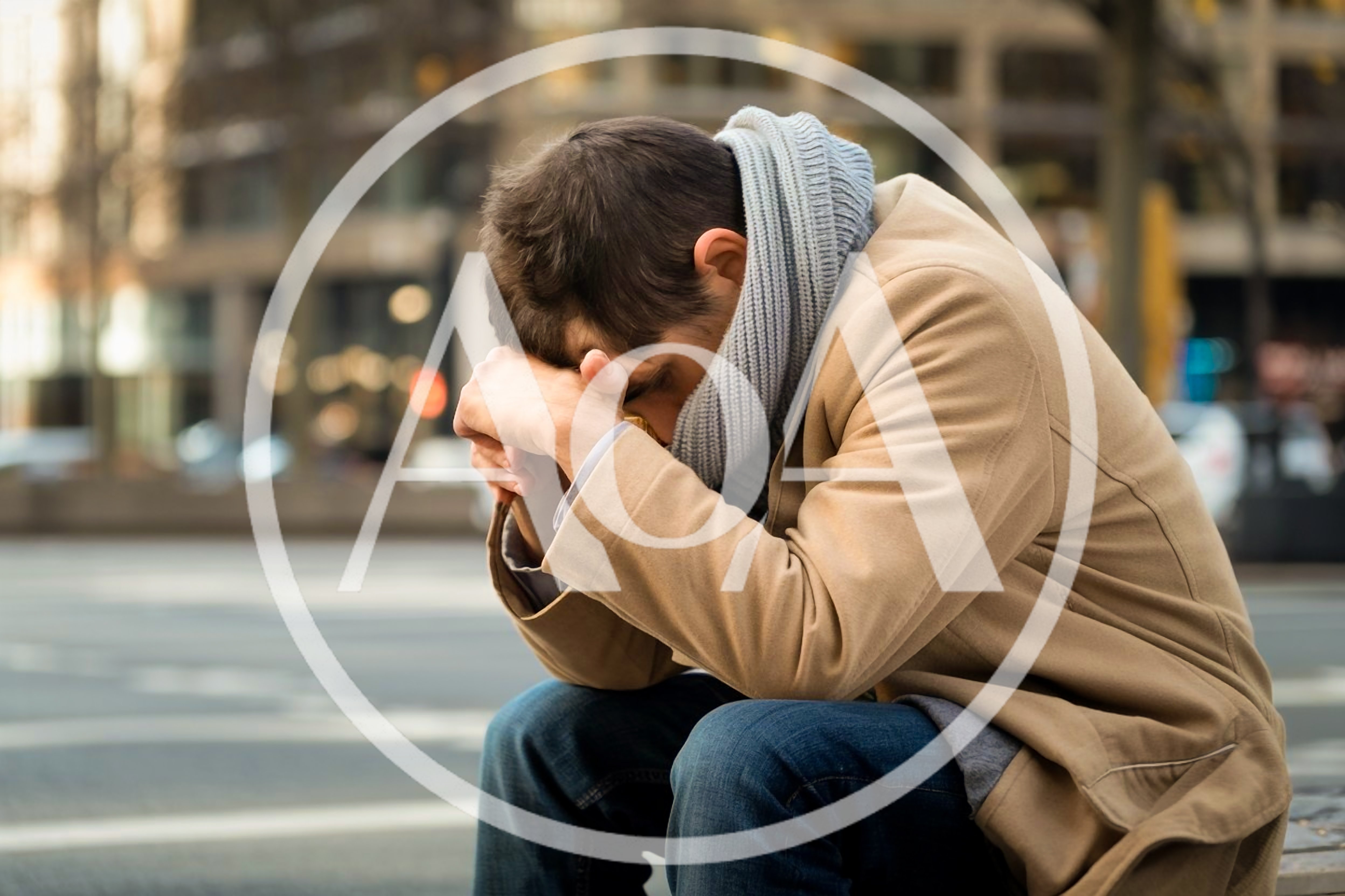 Depressed Man Sitting Alone On City Street