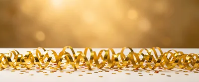 Golden Party Streamers and Confetti on White Surface