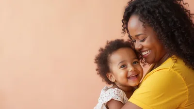 Happy Mother Holding Her Smiling Toddler Daughter
