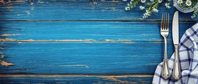 Silver Cutlery And Napkin On Blue Wooden Table