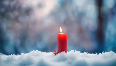 Single Red Candle Burning In Fresh Winter Snow