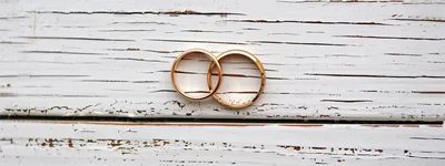 Two Gold Wedding Rings On Distressed White Wood