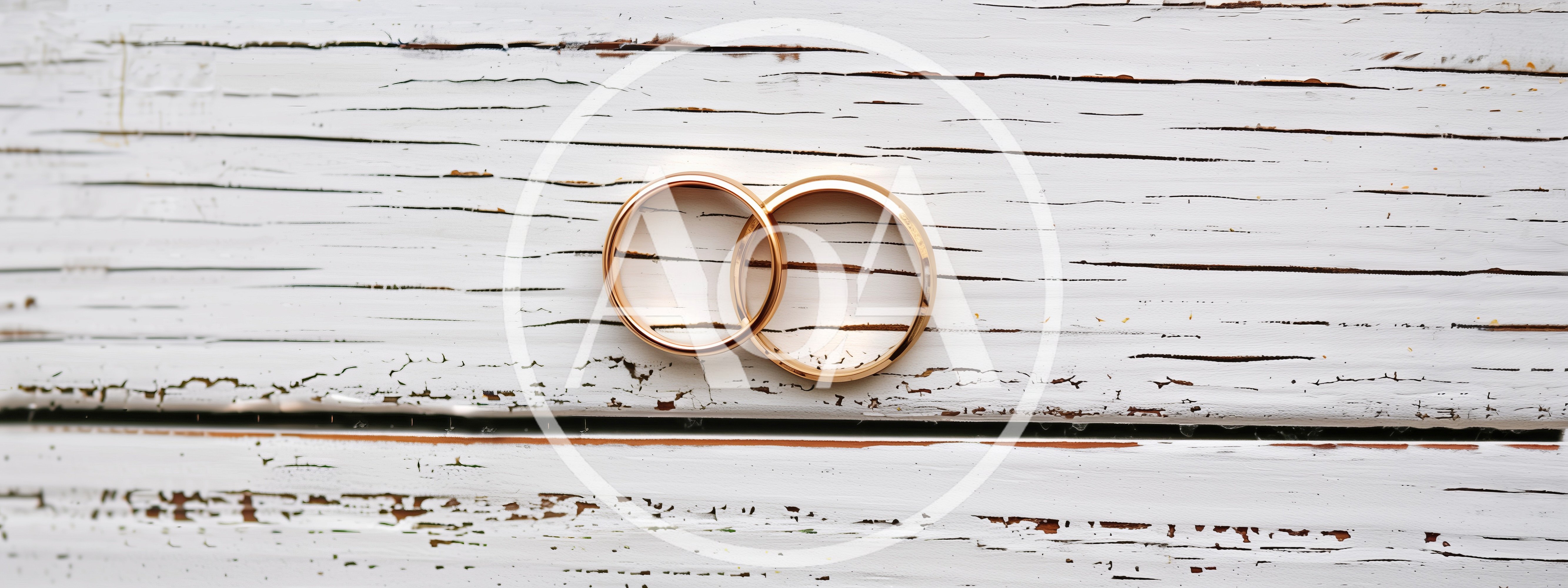 Two Gold Wedding Rings On Distressed White Wood