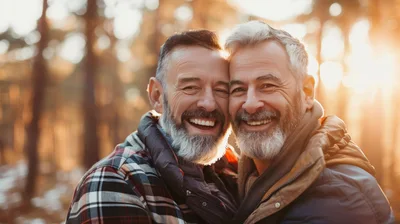 Two Mature Men Embracing Outdoors During Golden Hour