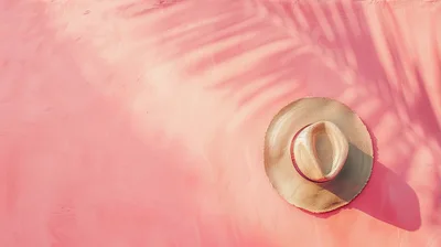 Straw Sun Hat on Pink Textured Background