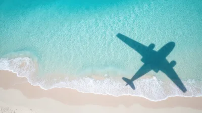 Aerial View Of Airplane Shadow Over Tropical Beach