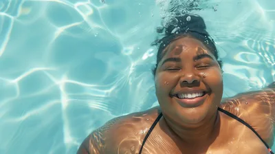 Happy Woman Floating In A Swimming Pool