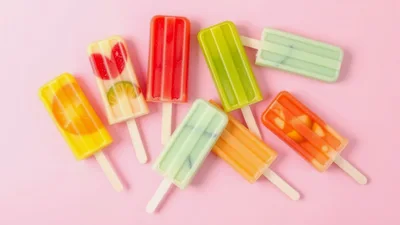 Assorted Fruit Popsicles On A Pink Background