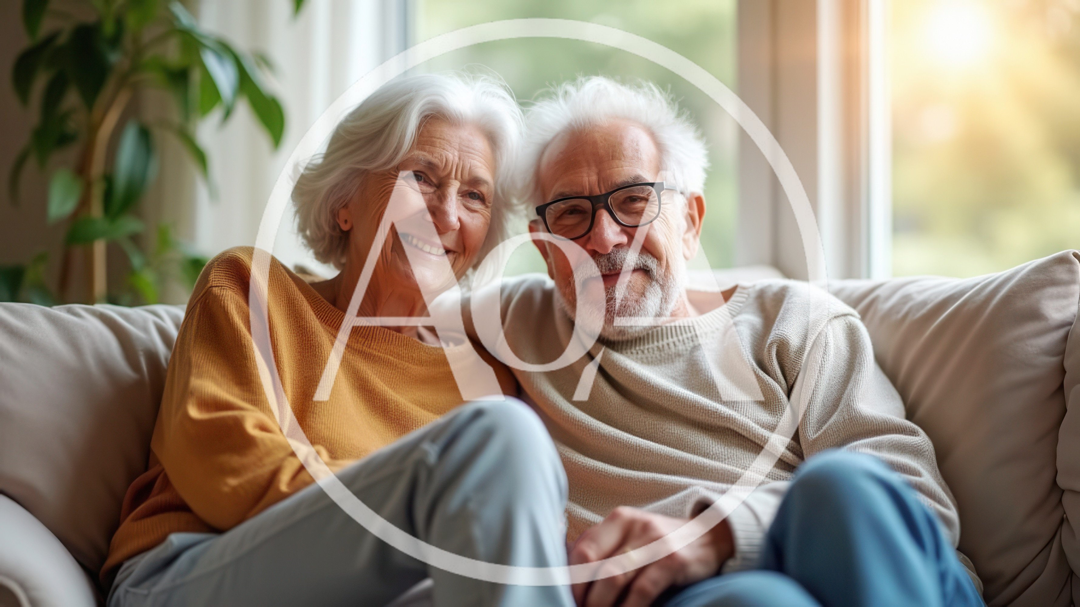 Happy Senior Couple Sitting Together On A Sofa