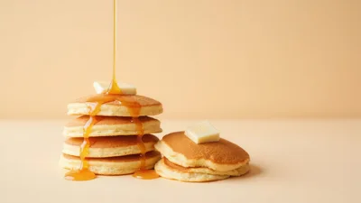 Stack Of Pancakes With Syrup Pouring And Butter
