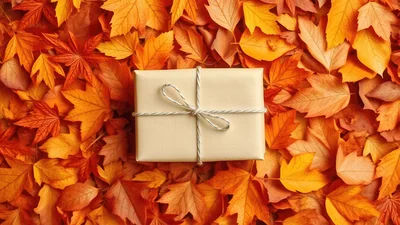 Gift Box Wrapped In Paper On Autumn Leaves