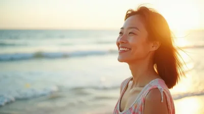 Happy Asian Woman Smiling At The Beach During Sunset