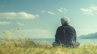 Elderly Person Sitting Alone In A Grassy Field