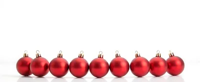 Row Of Red Christmas Ornaments On White Background