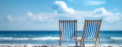 Two Striped Beach Chairs Facing The Ocean