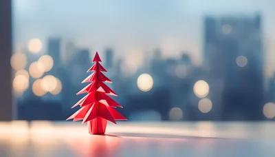 Red Origami Christmas Tree Against Blurred City Skyline