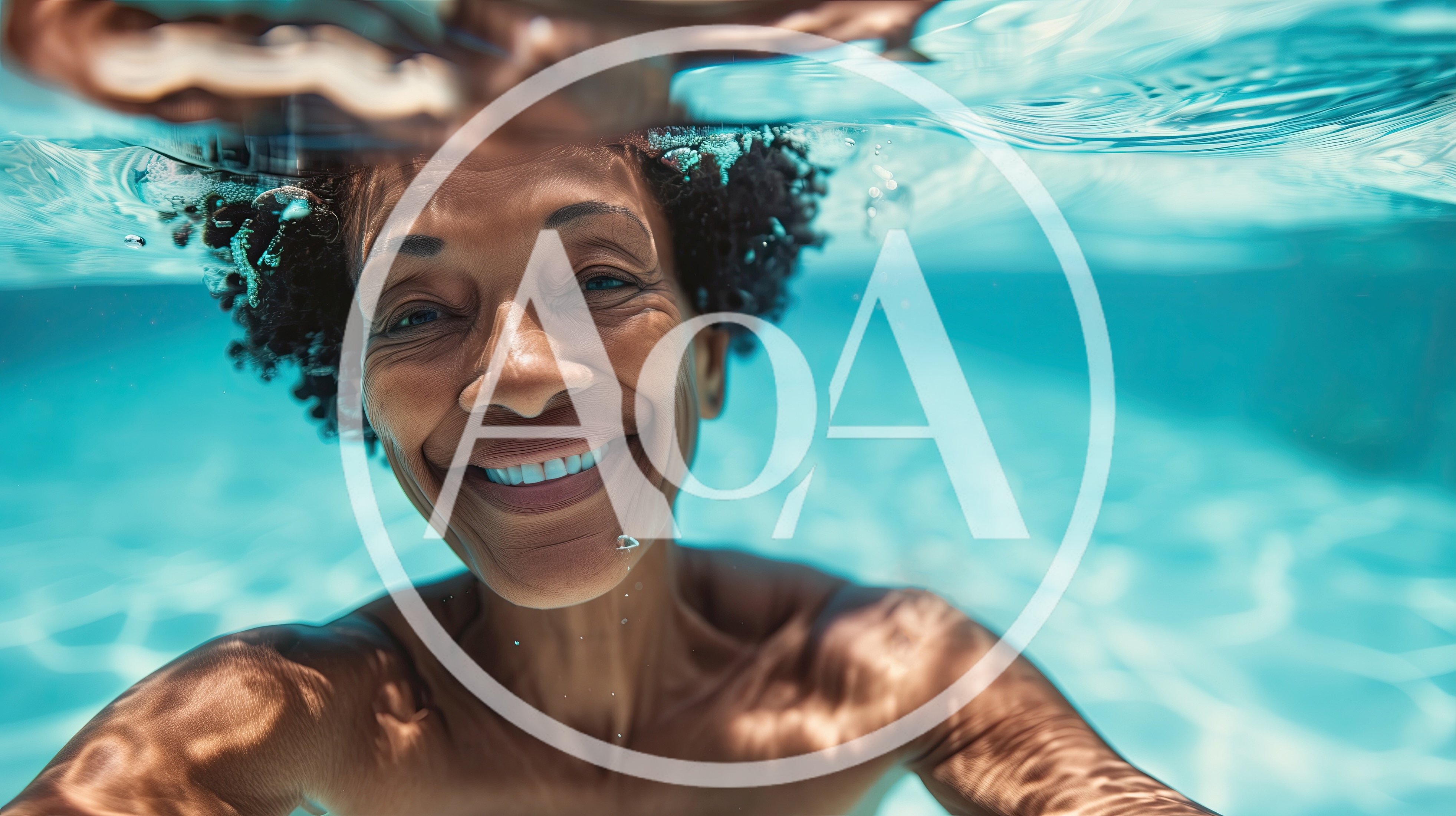 Smiling Mature Woman Swimming Underwater In A Pool