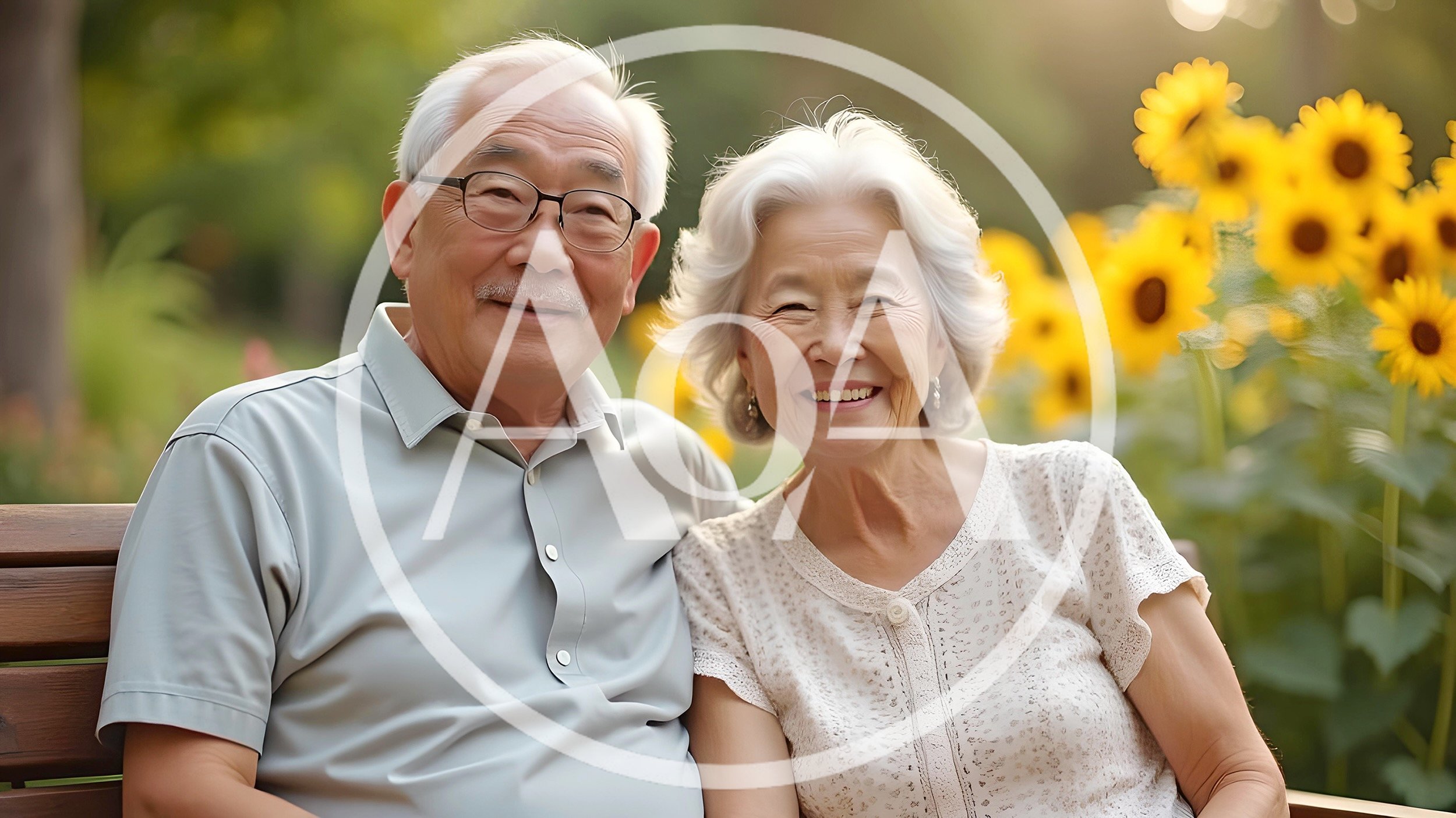 Happy Elderly Asian Couple Sitting Together On Park Bench