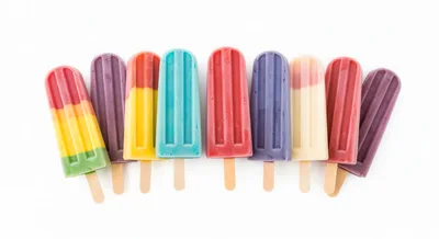 Assorted Colorful Fruit Popsicles on White Background