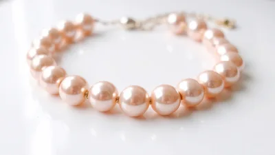 Elegant Pink Pearl Necklace on White Surface