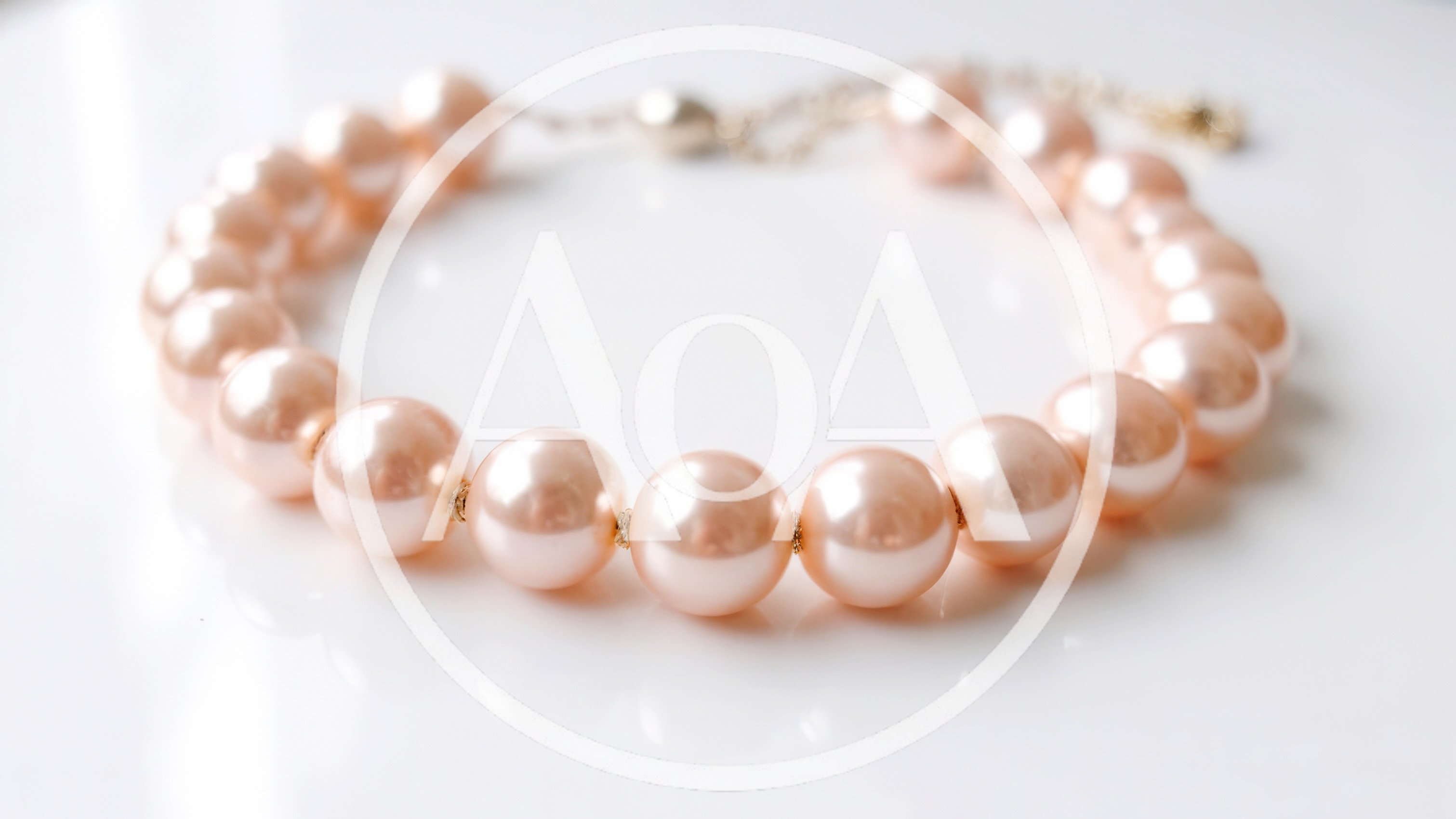 Elegant Pink Pearl Necklace on White Surface