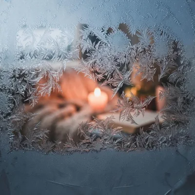 Frost Patterns On Window With Candlelight Background
