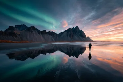 Lone Traveler Walking On Vestrahorn Beach Under Aurora Borealis