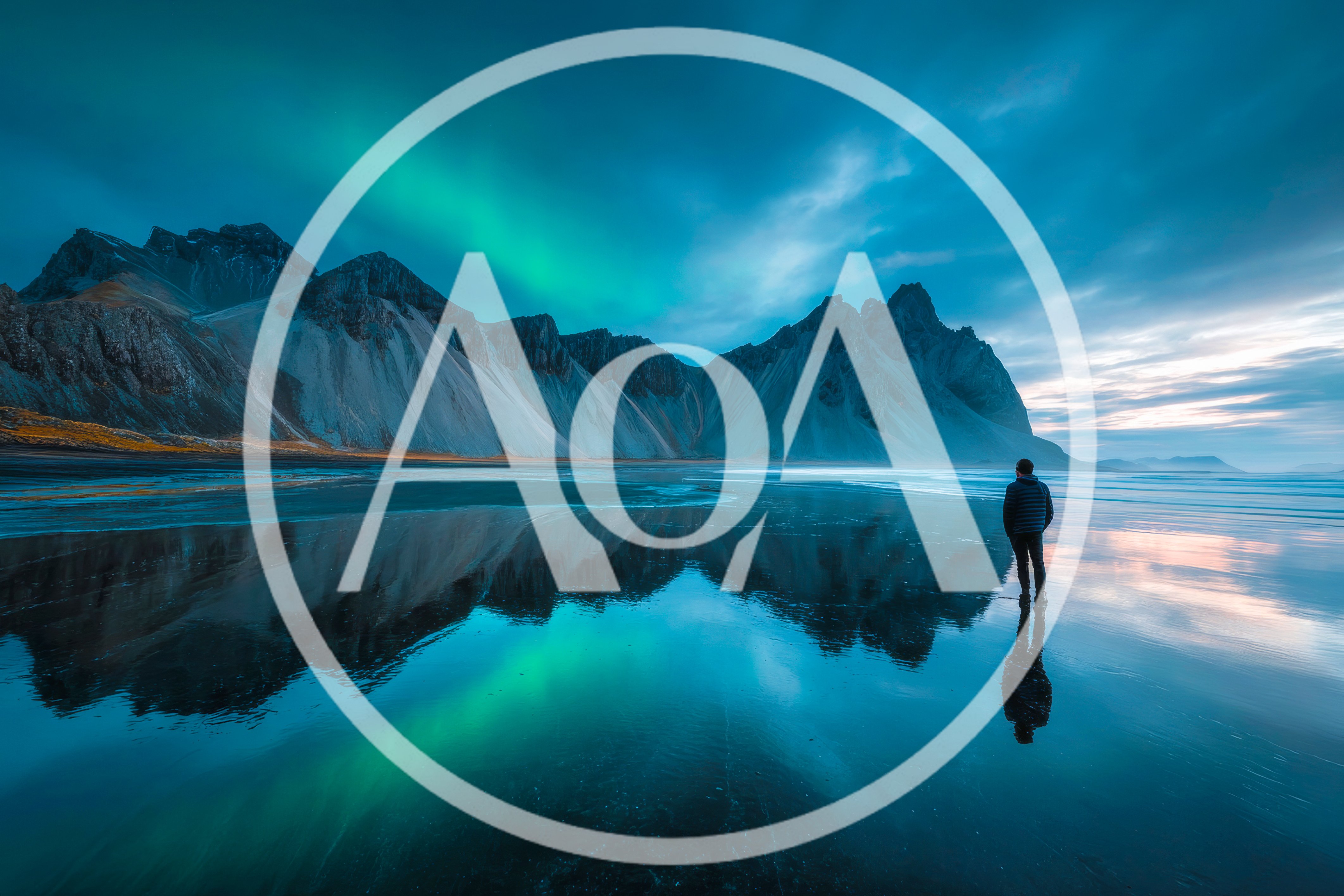 Man Standing On Reflective Beach Under Northern Lights