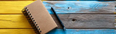 Spiral Notebook And Black Pen On Painted Wooden Table