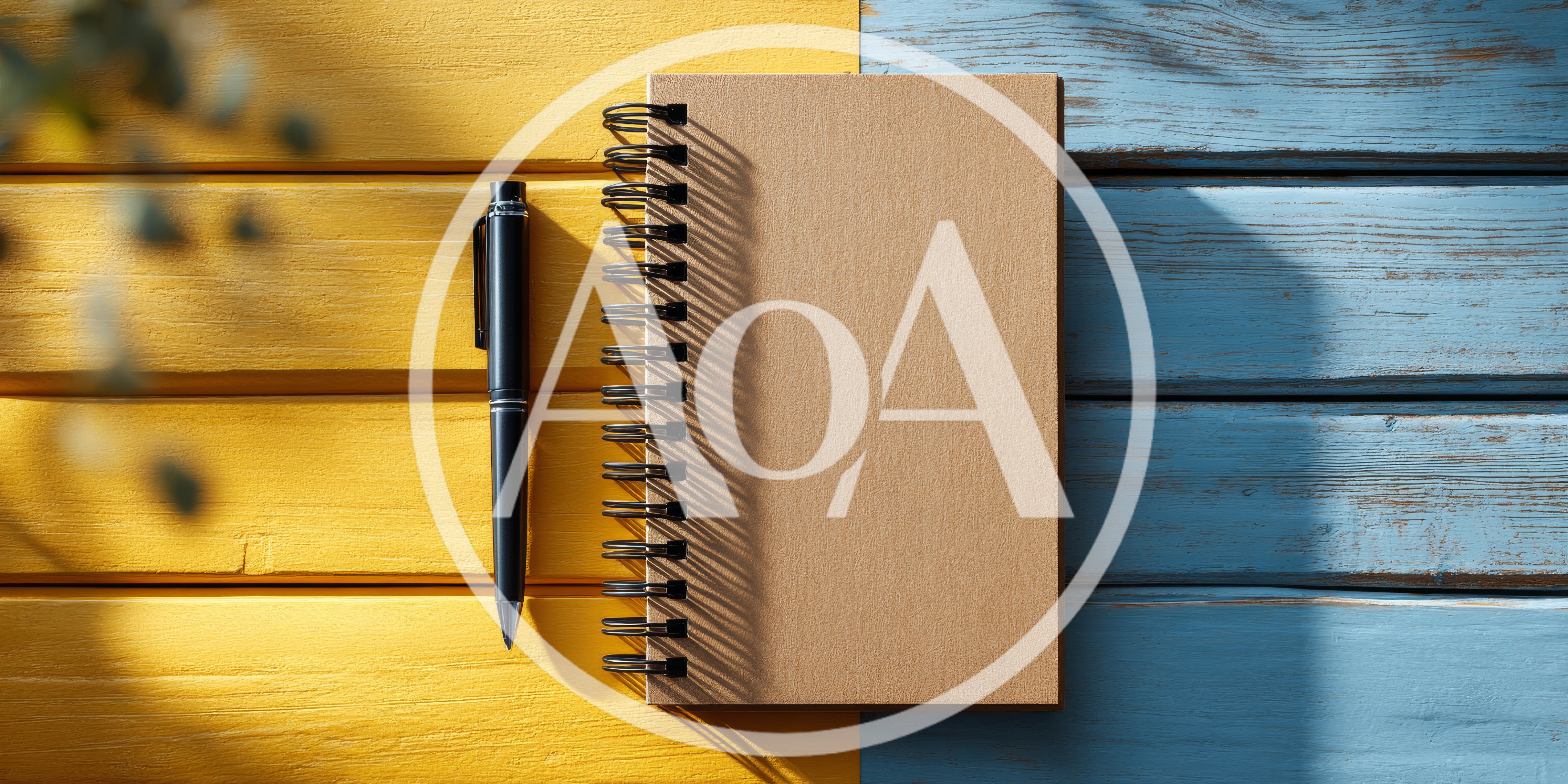 Spiral Notebook and Pen on Two Tone Wooden Background