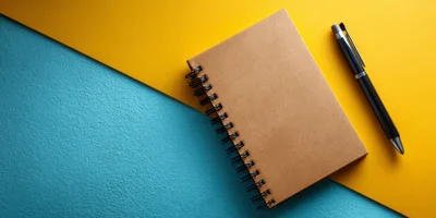 Spiral Notebook and Pen on Two Tone Background