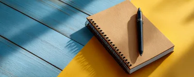 Spiral Notebook With Black Pen On Two Tone Background