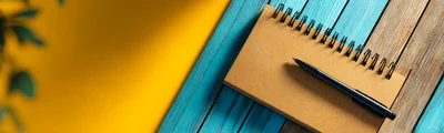 Spiral Notebook And Pen On Colorful Wooden Surface