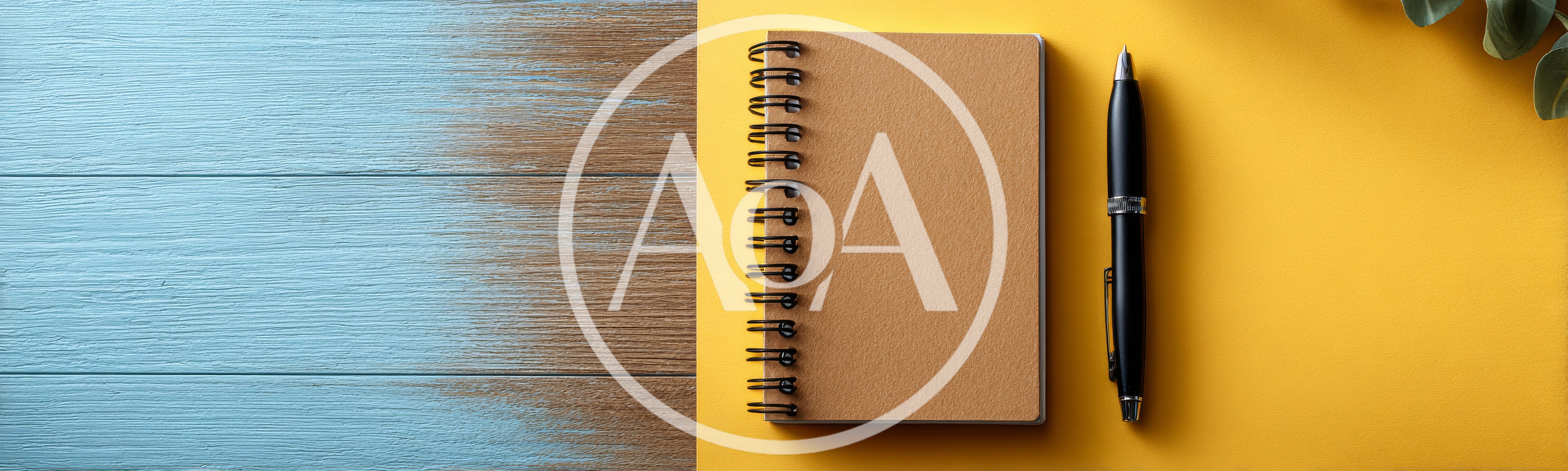 Spiral Notebook and Pen on Yellow and Wooden Background