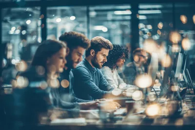 Diverse Professionals Working Late In Modern Office