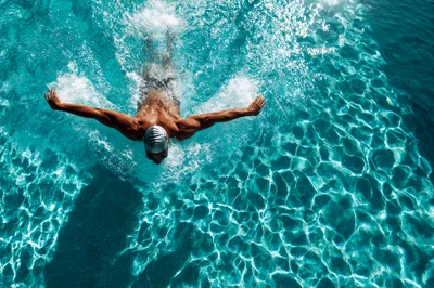 Professional Swimmer Performing Butterfly Stroke In Pool