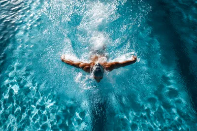Professional Swimmer Performing Butterfly Stroke In Pool