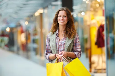 Young Woman Shopping With Yellow Bags In Mall