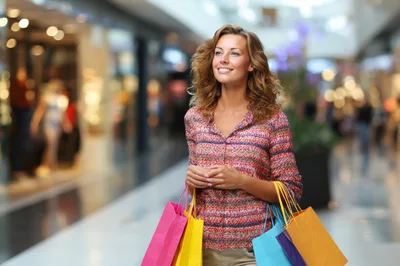 Happy Woman Carrying Shopping Bags In A Mall