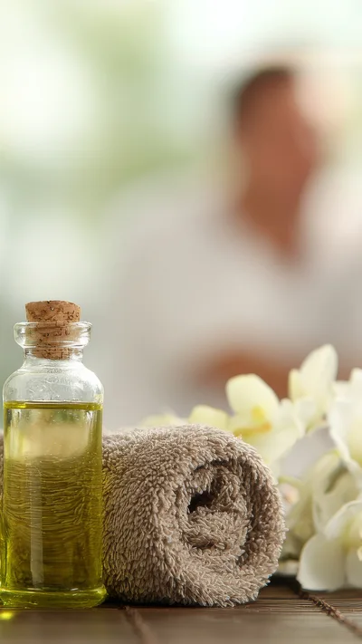 Spa Treatment Oil Bottle With Rolled Towel And Orchids