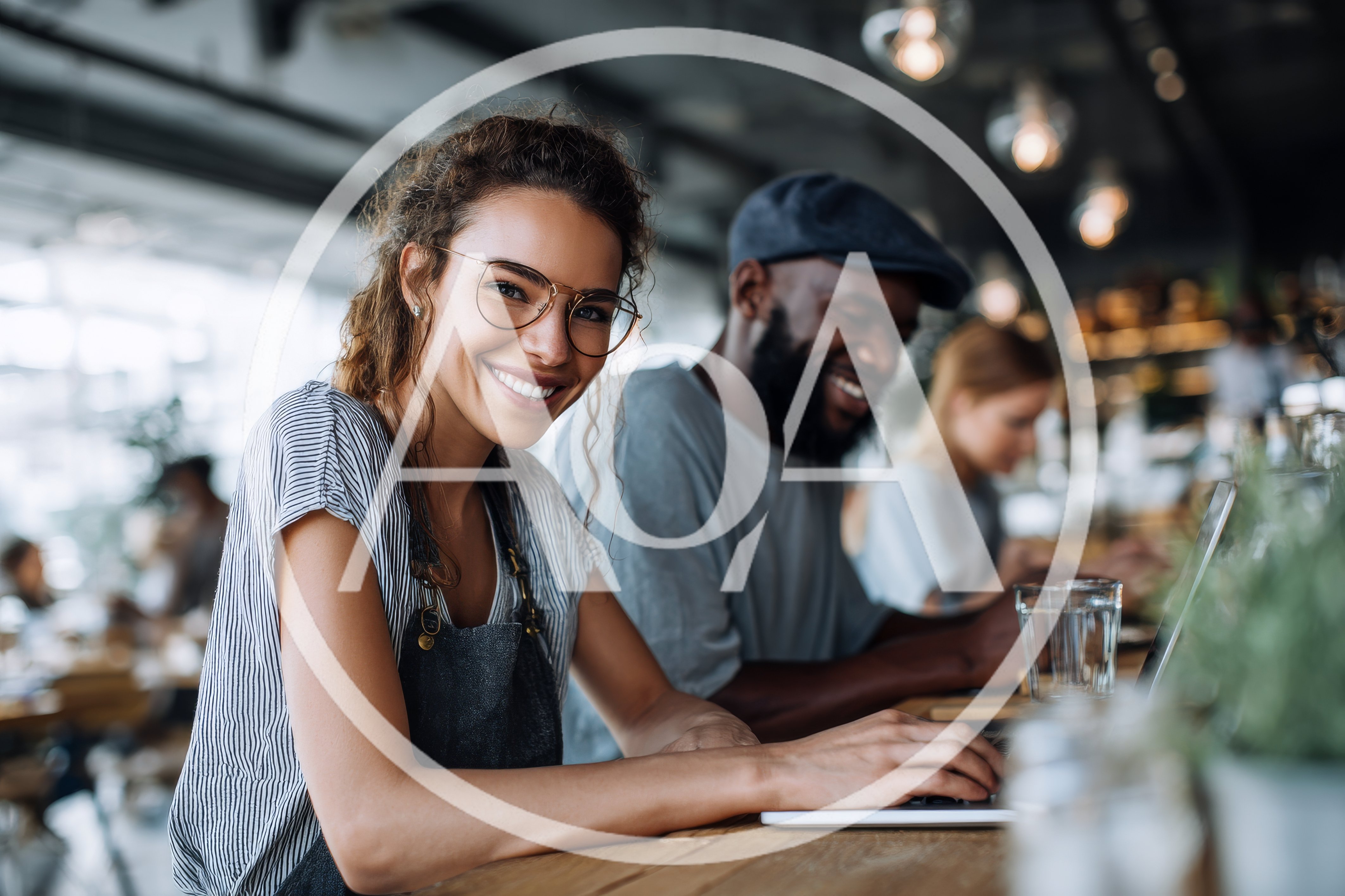 Smiling Female Barista Working On Laptop In Cafe