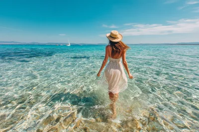 Woman Walking Into Clear Turquoise Sea