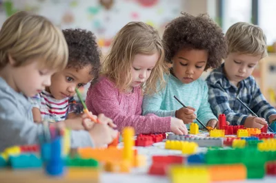 Diverse Preschool Children Drawing And Playing With Building Blocks