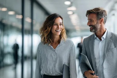 Professional Colleagues Walking and Talking in Modern Office Hallway