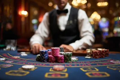 Casino Dealer Managing Poker Chips On Gaming Table