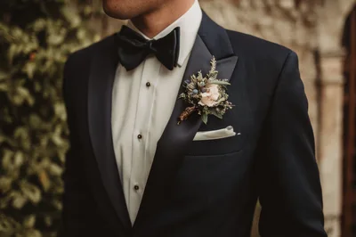 Groom Wearing A Navy Tuxedo With Floral Boutonniere