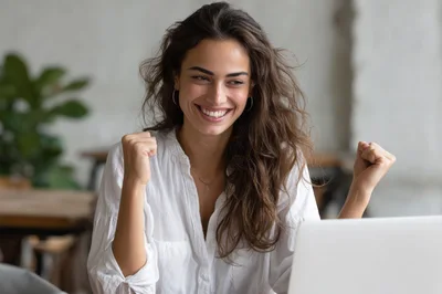 Excited Young Woman Celebrating Success On Laptop