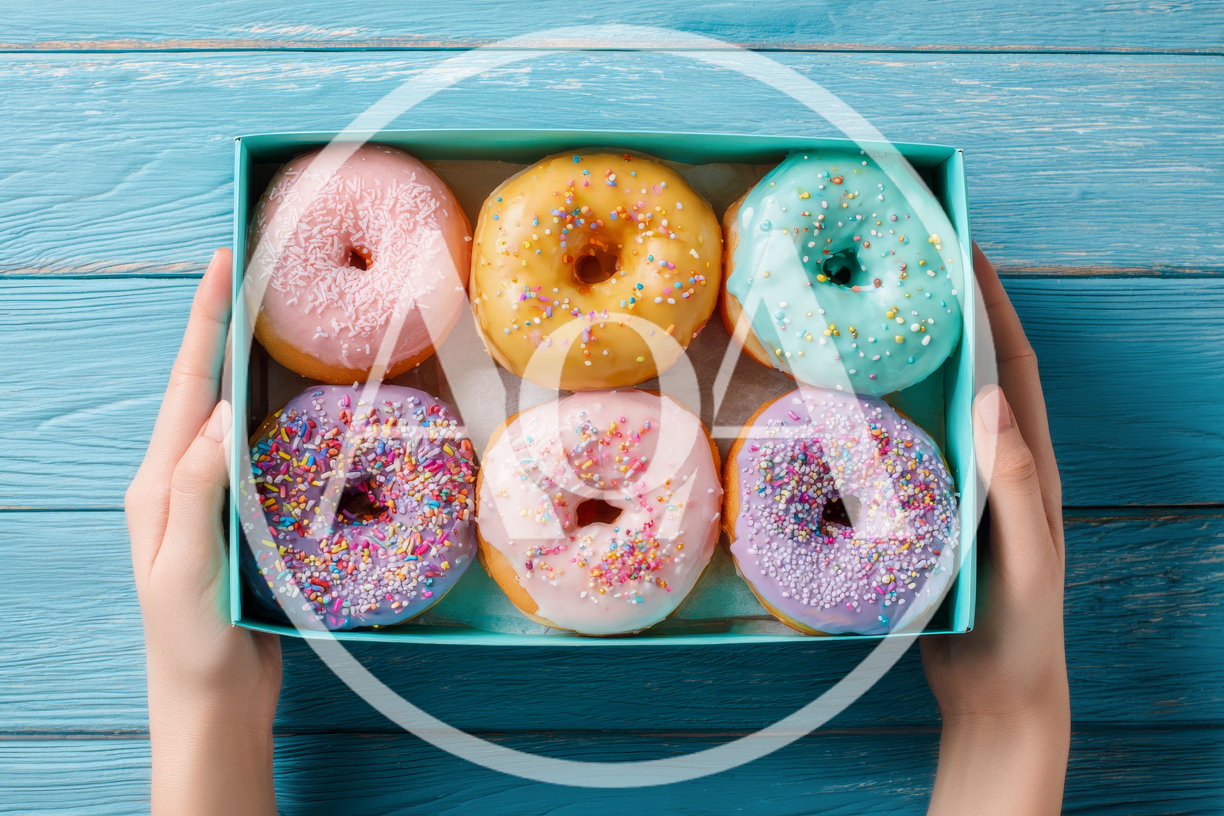 Hands Holding A Box Of Assorted Glazed Donuts