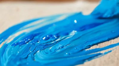Artist Painting Blue Acrylic Strokes On Canvas