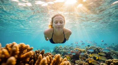Woman Swimming Underwater Over A Vibrant Coral Reef